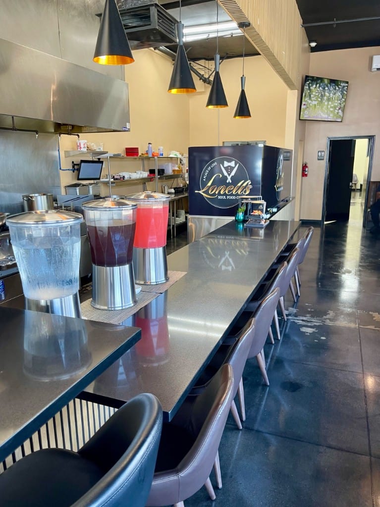 Counter seating with beverage dispensers and Lonell's Soul Food Cafe logo