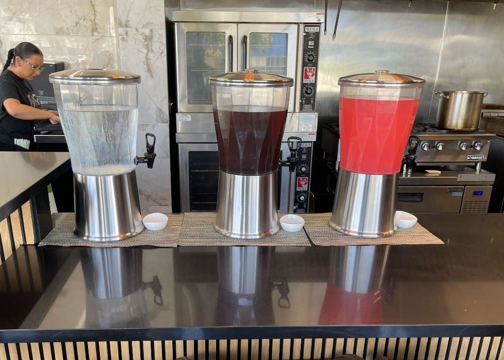 Beverage dispensers with water, iced tea, and fruit punch at the bar
