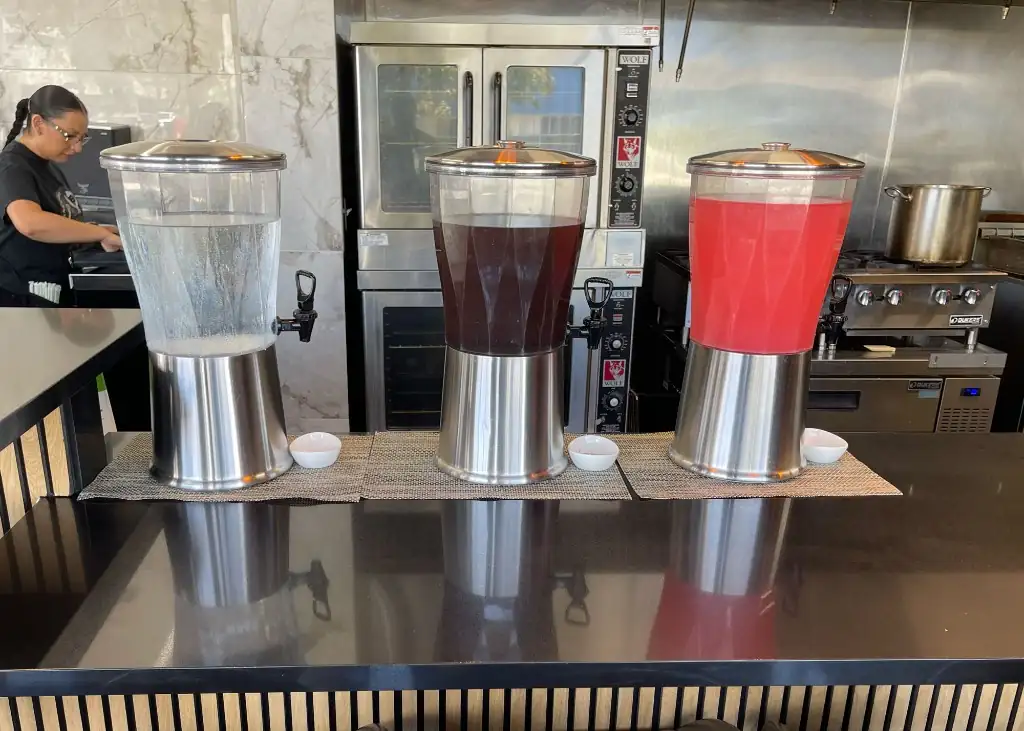Beverage dispensers with water, iced tea, and fruit punch at the bar
