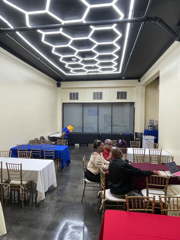 Private event space with hexagonal ceiling lighting and banquet tables