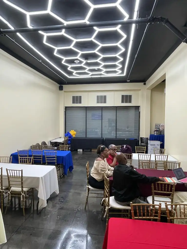 Private event space with hexagonal ceiling lighting and banquet tables