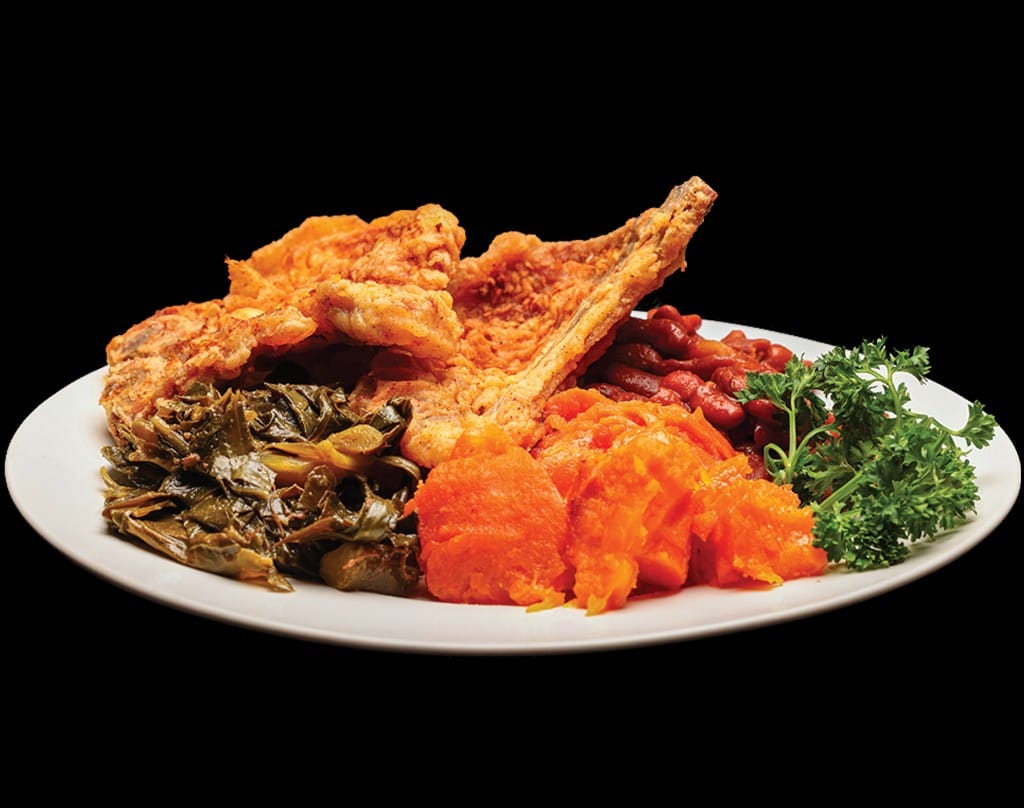 Golden fried pork chop dinner with collard greens, candied yams, and red beans at Lonell's Soul Food